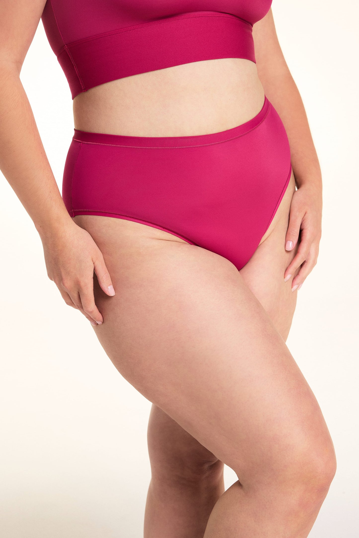 On a light studio backdrop, Alessandra wears the Bliss Highwaist underwear in Winterberry. The angled close-up highlights the high-rise silhouette, smooth fabric, and full-coverage design.