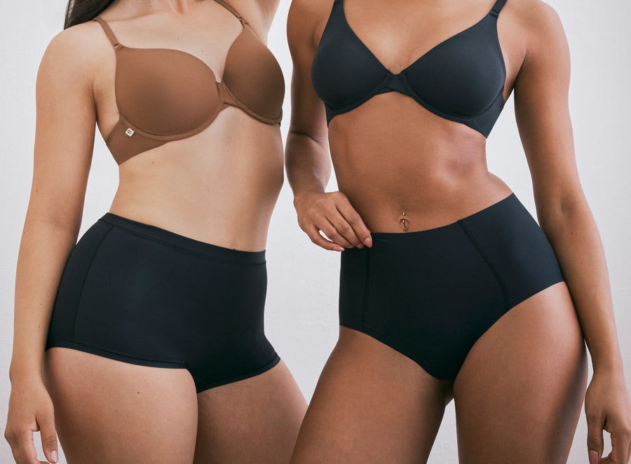 Models Emerysn and Ally showcasing Harper Wilde intimates. Emerysn wears the Base T-Shirt Bra in Brown paired with the Bliss Boyshort in Black, while Ally wears the Base Unlined Bra with the No-Show Highwaist Brief in Black.