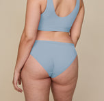 Back view of Summerlyn wearing the Bliss Bikini in Glacier. The image showcases the moderate back coverage and smooth fit of the fabric across the hips and waist, with the matching Bliss Bralette visible above.