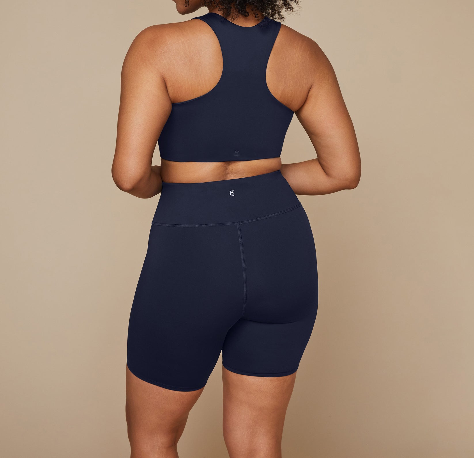 Close up of the back waist of the bike shorts showing the Harper Wilde "H" logo at the top center.