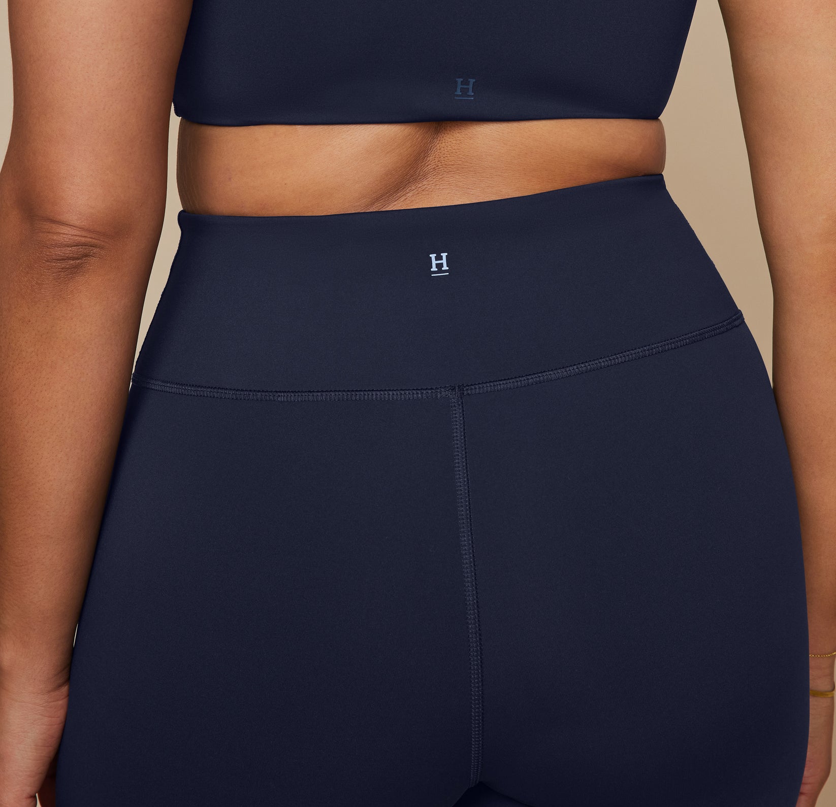 Close up of the back waist of the bike shorts showing the Harper Wilde "H" logo at the top center.