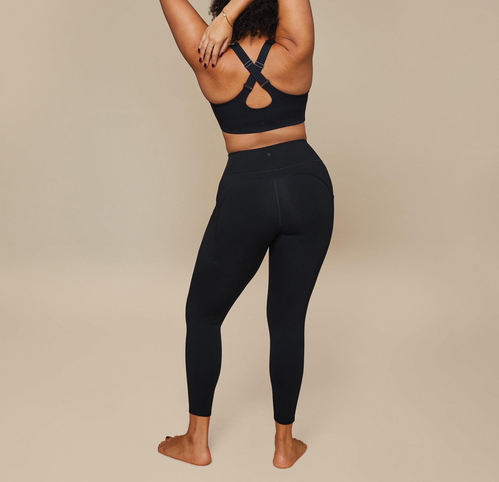 Back view of model wearing the Flex Crossback Convertible Sports Bra and matching Flex High Rise Leggings in Black.