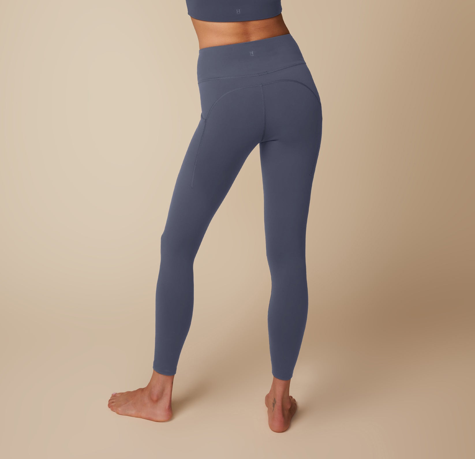 Anna modeling the Flex High Rise Legging and Flex Active Tank in Slate, highlighting the back and side details.