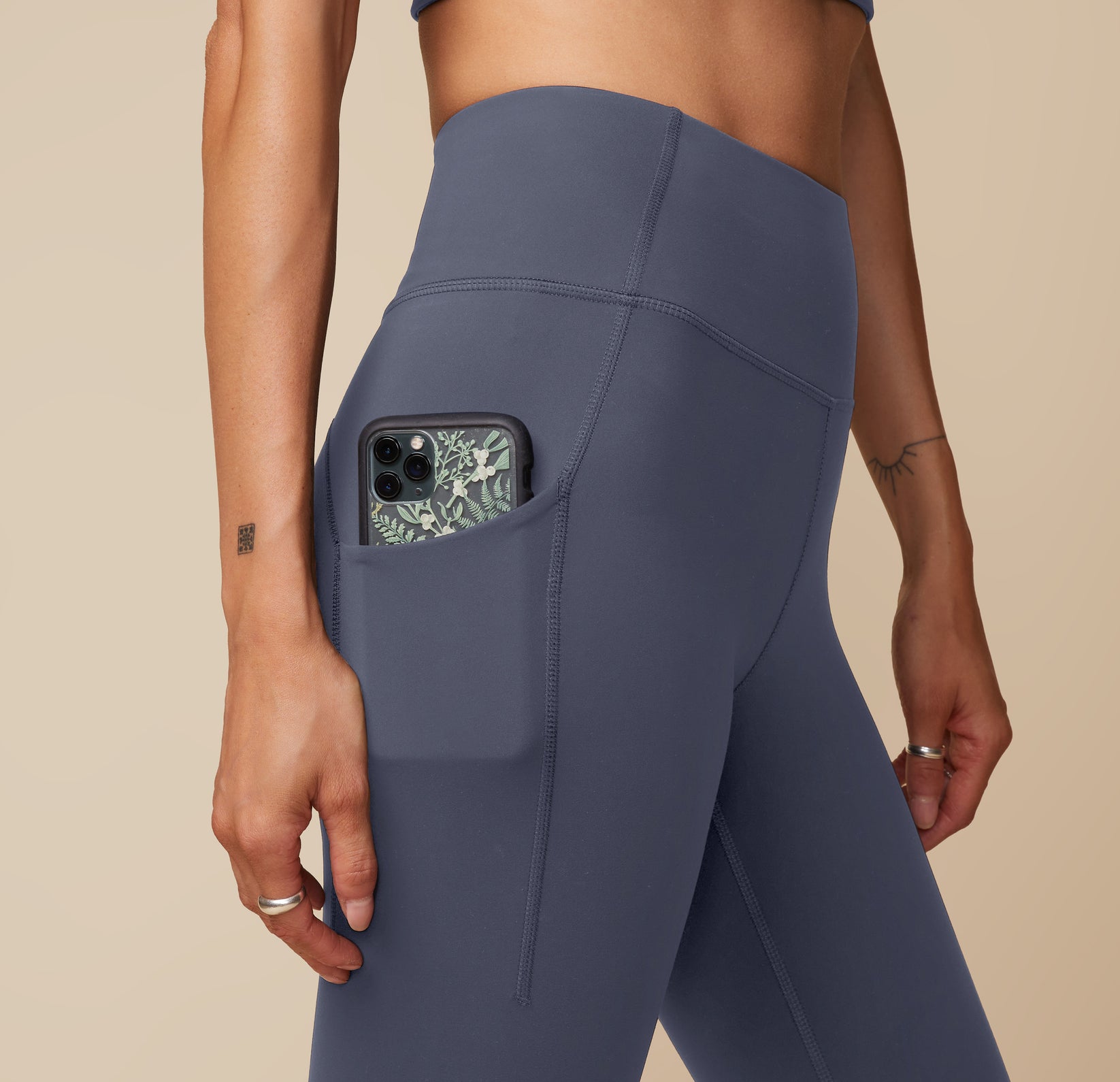 Close-up of the Flex High Rise Legging in Slate, showing the convenient side pocket detail holding an iPhone.