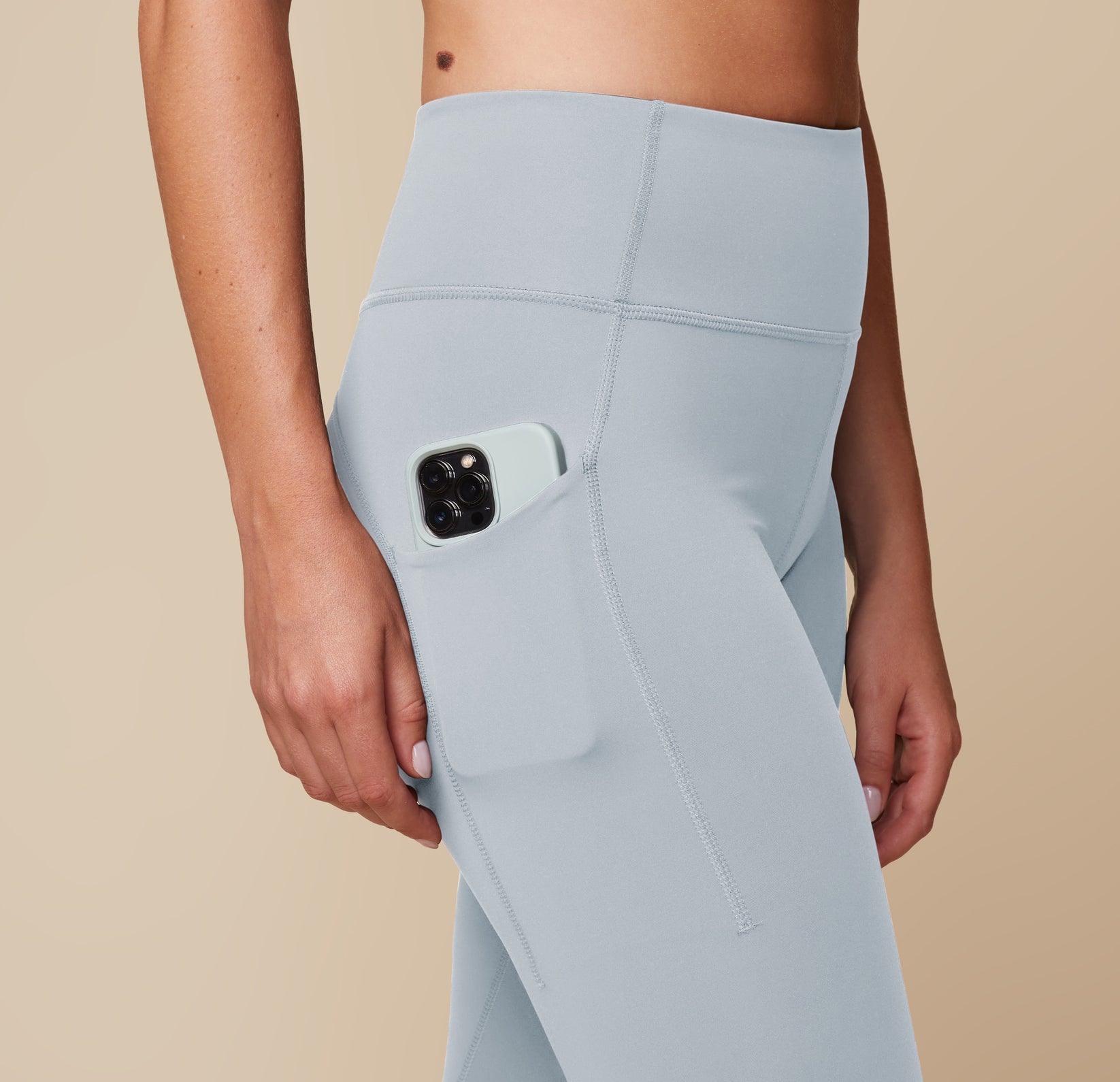 Close-up of the Flex High Rise Legging in Thistle, highlighting the side pocket detail holding an iPhone.