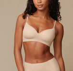 Model Ally wearing the Base Wirefree Bra in Beige, showcasing the molded, lightly lined cups that provide natural shape and wire-free support. Adjustable straps are visible for a customizable fit. sizing: Ally wears size 32C