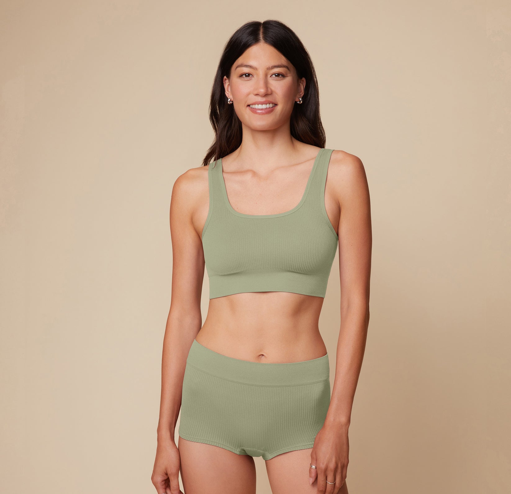 Model Anna stands in the Lounge Scoop Bralette and Lounge Boyshort in Sage, showcasing the comfortable fit and soft fabric of both pieces. sizing: Anna wears size Small