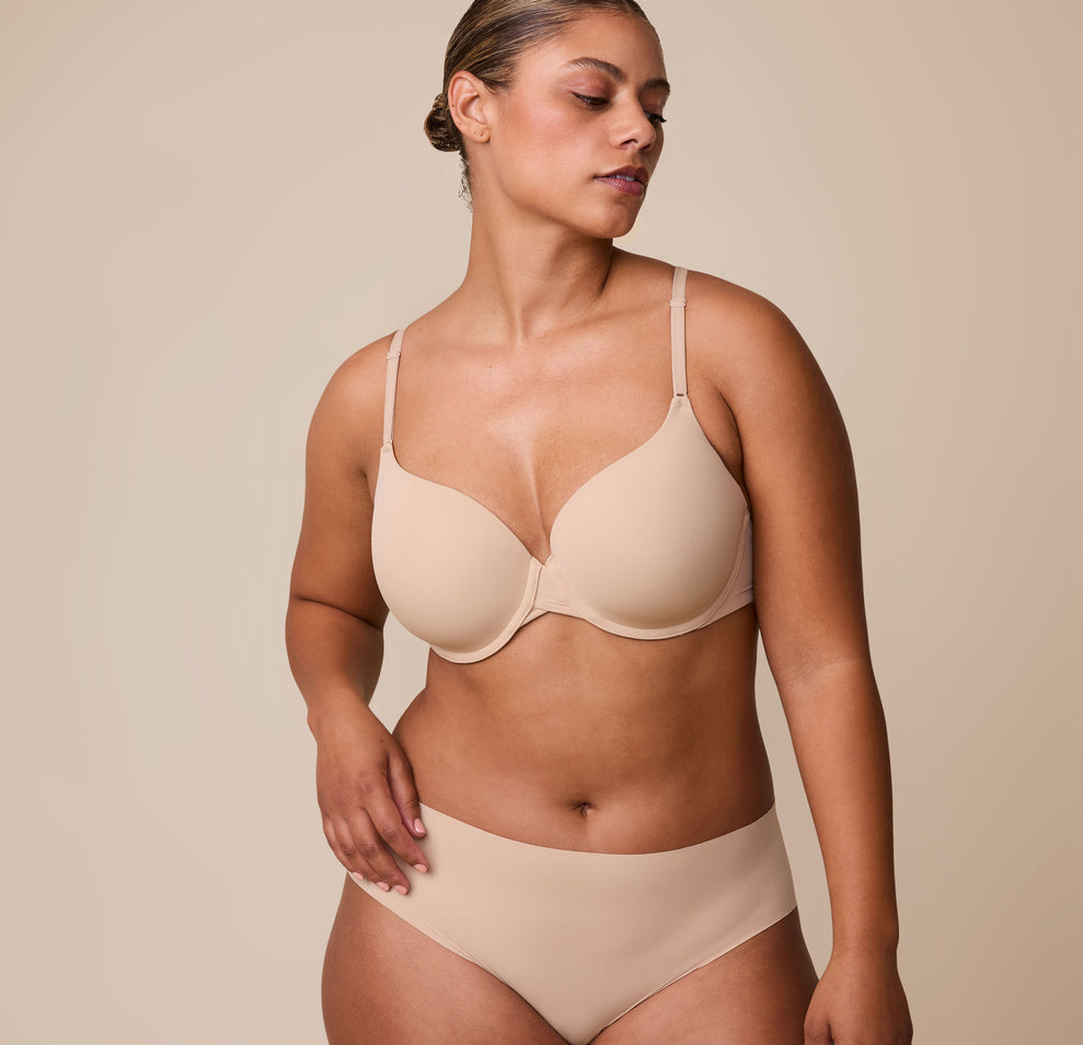 India wears the Base T-Shirt Bra in Beige, highlighting the lightly lined cups, supportive underwire, and ultra-soft fabric designed for all-day comfort. sizing: India wears size 36D