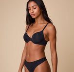 Ally poses in a three-quarter angle wearing the Base T-Shirt Bra in Black, highlighting the contoured fit and comfortable coverage.