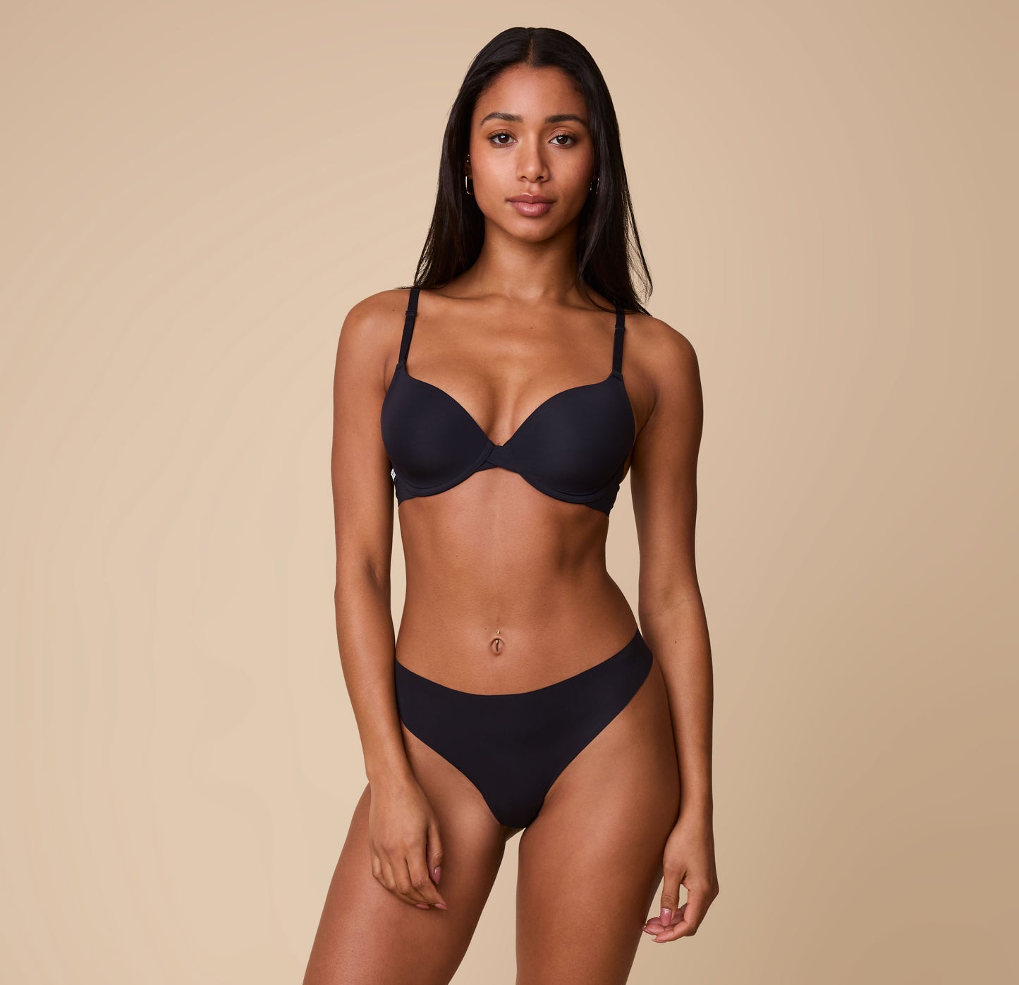 Full-body image of Ally wearing the Base T-Shirt Bra in Black, showcasing the bra’s lightly padded cups and supportive fit.