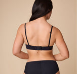 Emersyn displays the back of the Base T-Shirt Bra in Black, showing the adjustable band, convertible racerback feature, and overall comfortable fit.