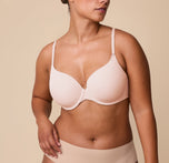 India models the Base T-Shirt Bra in Rose, showing a front view of the bra's smooth design with lightly padded cups and front adjustable straps. sizing: India wears size 36D