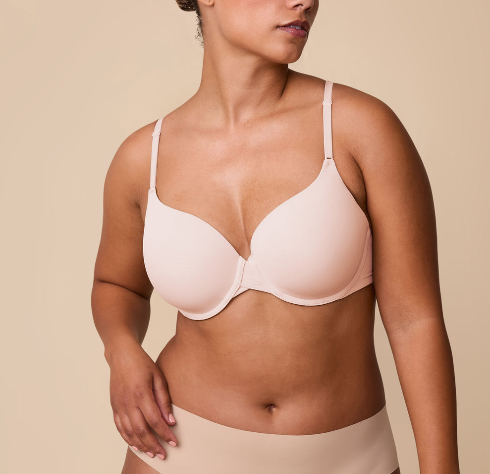 India models the Base T-Shirt Bra in Rose, showing a front view of the bra's smooth design with lightly padded cups and front adjustable straps. sizing: India wears size 36D