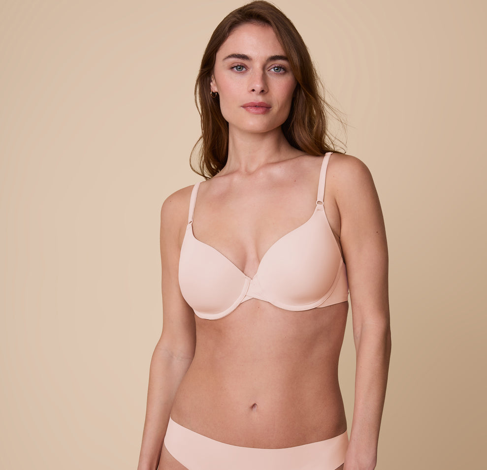 Gracie models the Base T-Shirt Bra in Rose, standing in a relaxed pose to highlight the smooth, form-fitting design. sizing: Gracie wears size 32D