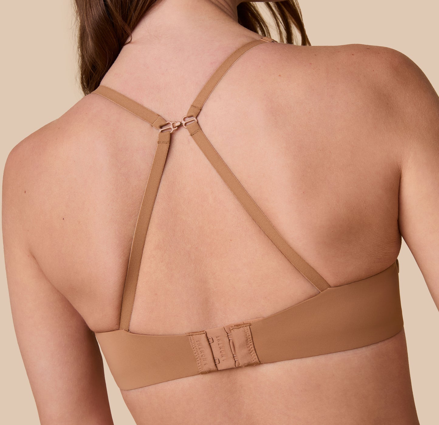 Gracie models the Base T-Shirt Bra in Tan with the straps converted into a racerback style, highlighting the bra’s versatile design.