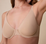 A close-up of Gracie in the Base Unlined Bra in Beige, focusing on the seamless design, silky-soft fabric, and unlined cups that enhance the natural shape.