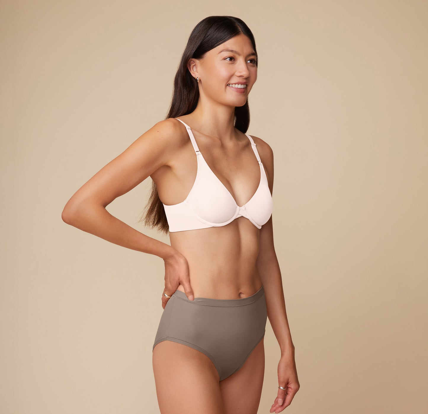 Three quarter view of Anna wearing the Base Unlined Bra in Quartz. The thick, comfortable band and plunging neckline are emphasized.