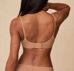 A back view of Ally wearing the Base Unlined Bra in Tan, highlighting the adjustable straps, convertible racerback feature, and hook-and-eye closure for a customizable fit.