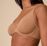 A close-up of Ally wearing the Base Unlined Bra in Tan, emphasizing the soft, unlined cups and supportive underwire for a barely-there feel.