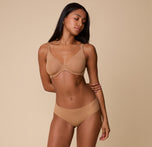 A full-body shot of Ally in the Base Unlined Bra in Tan, paired with the matching No-Show Hiphugger, highlighting the lightweight, second-skin fit.