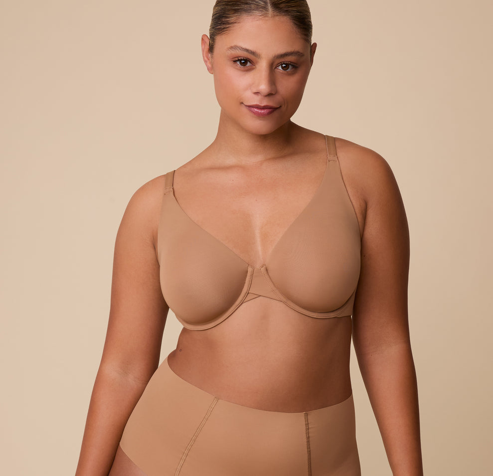India models the Base Unlined Bra in Tan in a front-facing pose, highlighting the sleek, supportive design made from smooth, ultra-soft fabric. sizing: India wears size 36D