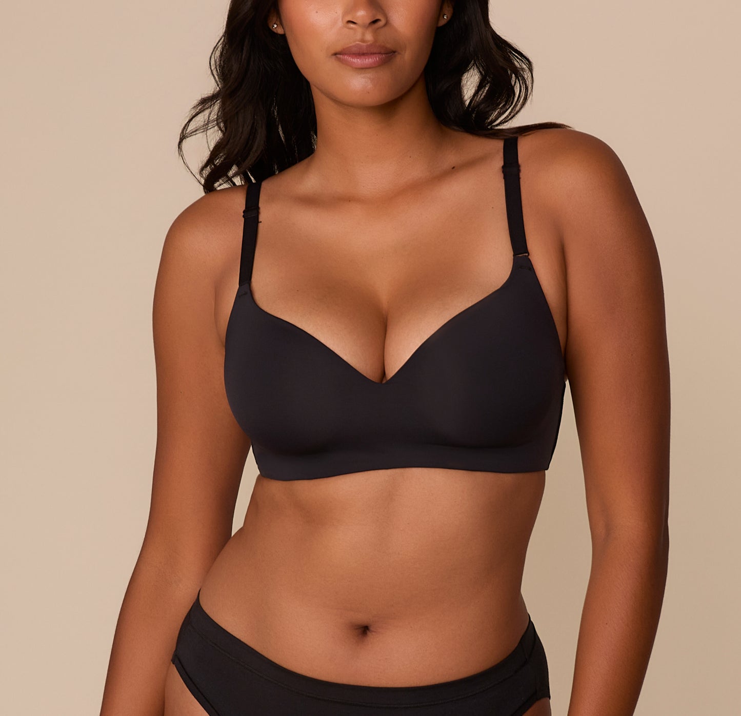 Front view of Victoria wearing the Base Wirefree T-Shirt Bra in Black. The lightly lined cups and smooth microfiber fabric offer a sleek, comfortable fit with a plunging neckline and adjustable straps. sizing: Victoria wears size 32DD