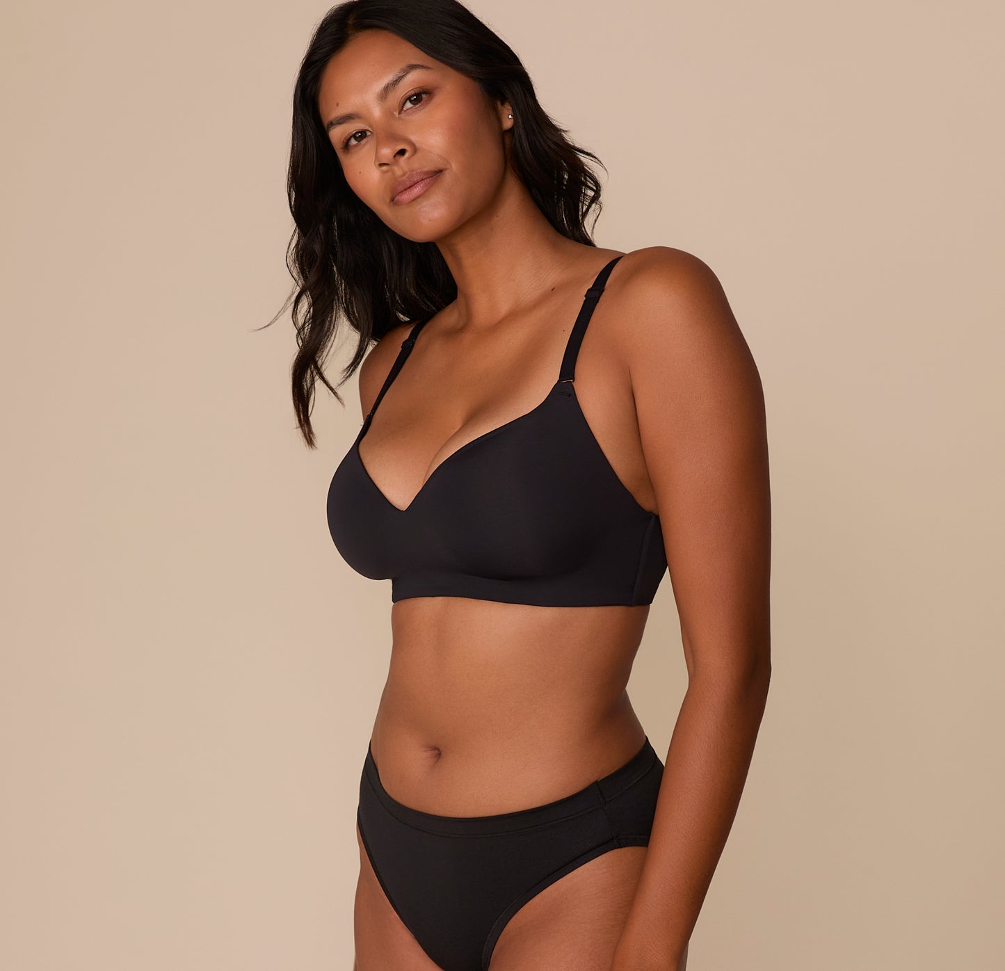 Three-quarter angle of Victoria in the Base Wirefree T-Shirt Bra in Black, showing the contoured cups and soft, stretch fabric that molds to the body for a smooth silhouette.