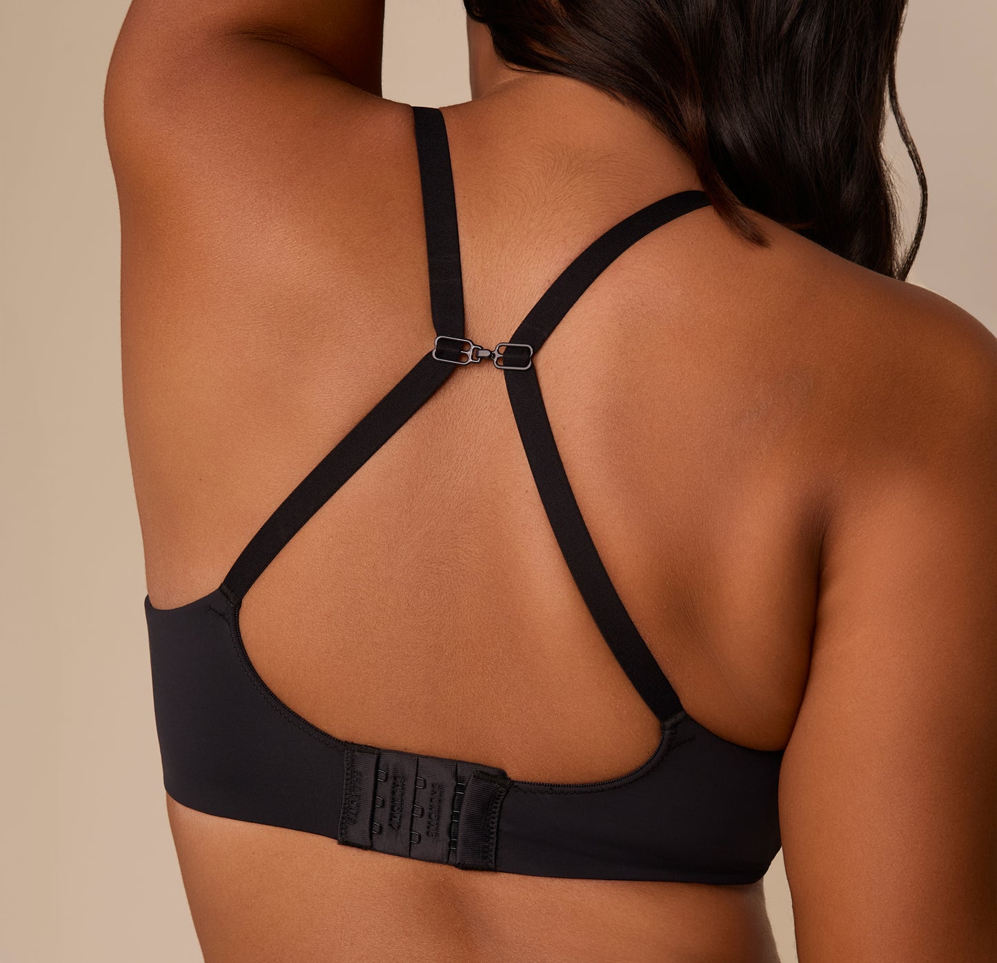 Victoria wearing the Base Wirefree T-Shirt Bra in Black with straps clipped into a racerback using the sliding J-hook. The image shows the versatile fit option and supportive back band.