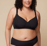 Bianca wears the Base Wirefree Bra in Black, showcasing its molded, lightly lined cups that provide natural shape without bulk. The adjustable straps are visible, emphasizing a customizable fit. sizing: Bianca wears size 38F