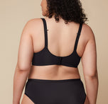 A close-up of Bianca’s back in the Base Wirefree Bra in Black. The ballet back design offers sleek support, while the J-hook feature is highlighted, allowing easy conversion to a racerback.