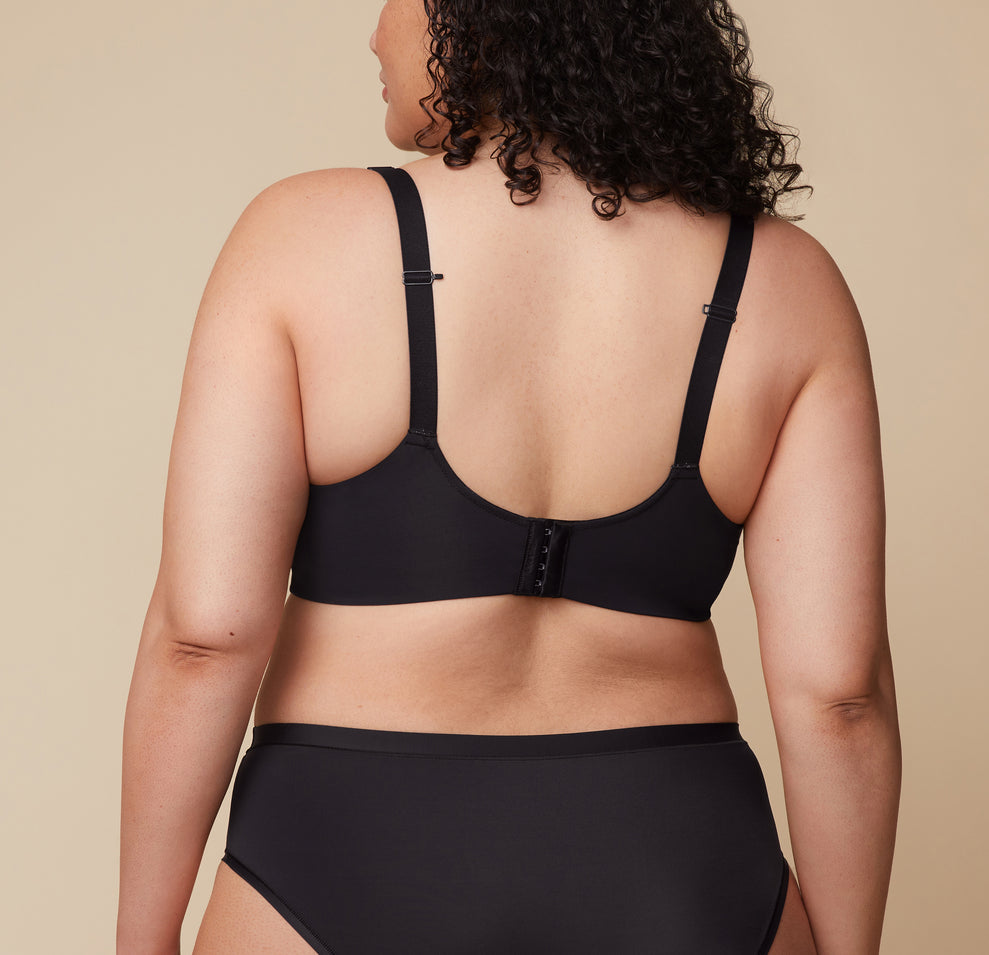 A close-up of Bianca’s back in the Base Wirefree Bra in Black. The ballet back design offers sleek support, while the J-hook feature is highlighted, allowing easy conversion to a racerback.
