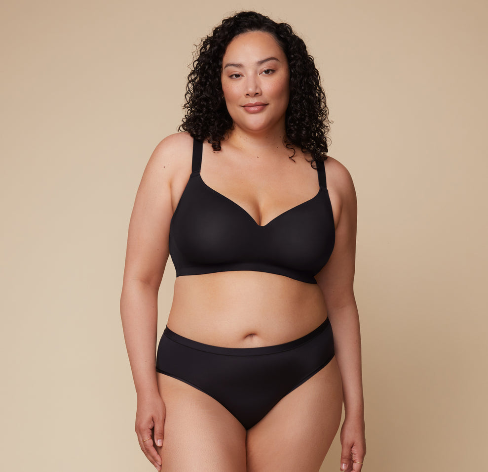 Bianca faces the camera wearing the Base Wirefree T-Shirt Bra in Black and the Bliss Hiphugger in the matching color.
