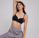 Anna wears the Base Wirefree Bra in Black, paired with tailored pants, showcasing its modern design that blends style and comfort effortlessly.