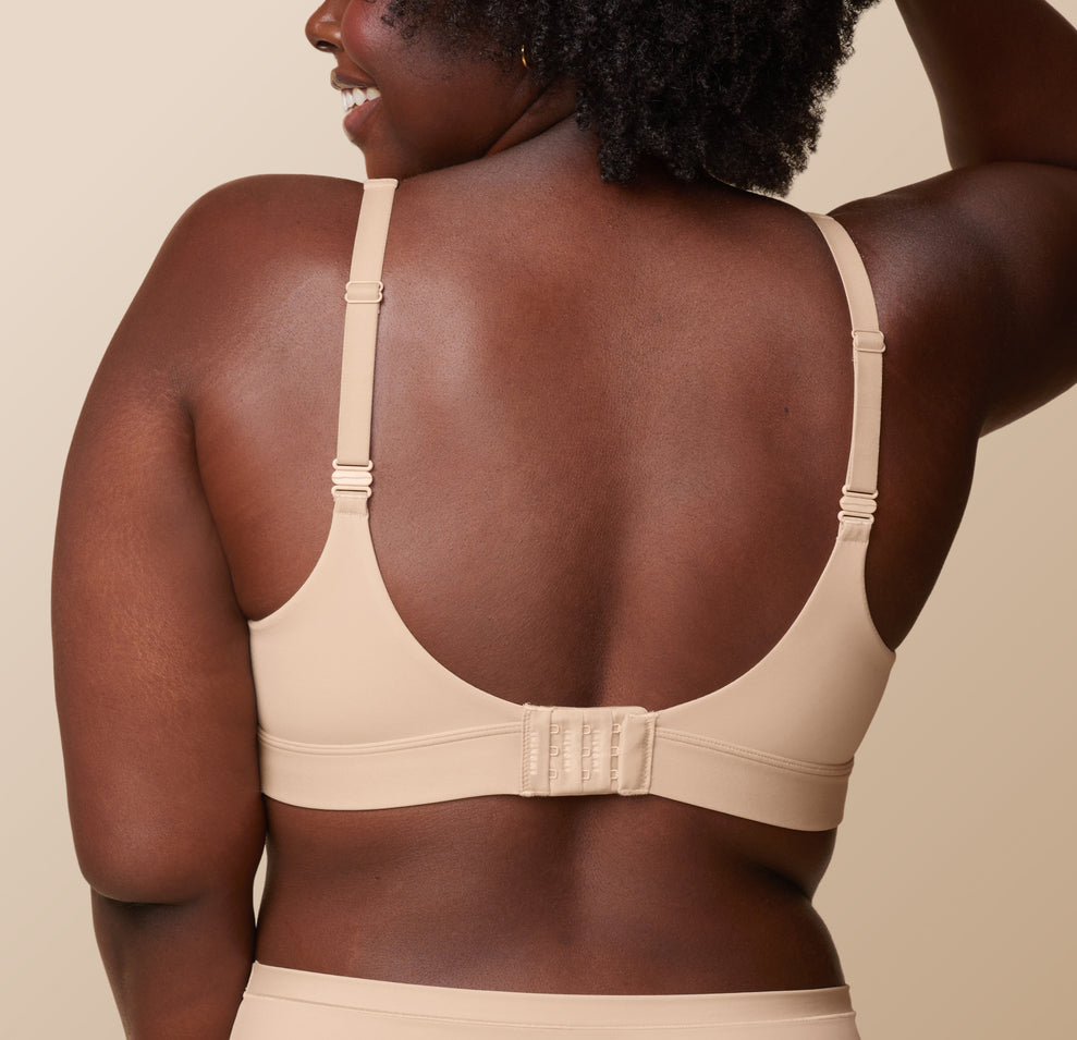 Back view of Akesha in the Bliss Plunge Adjustable Bralette in Beige, highlighting the standard strap configuration.