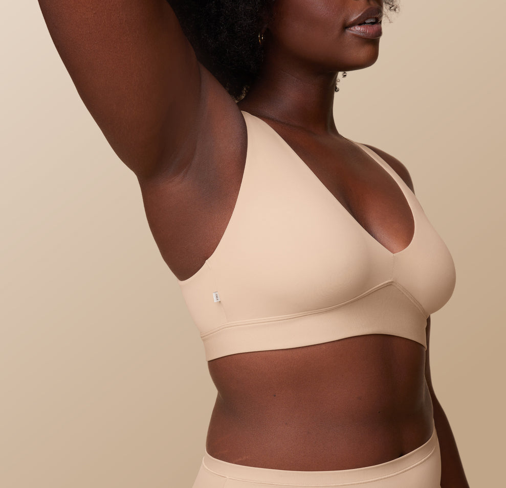 Side view of Akesha in the Bliss Plunge Adjustable Bralette and Bliss Highwaist Brief in Beige, highlighting the adjustable straps and smooth fabric of the bralette, perfect for all-day wear.