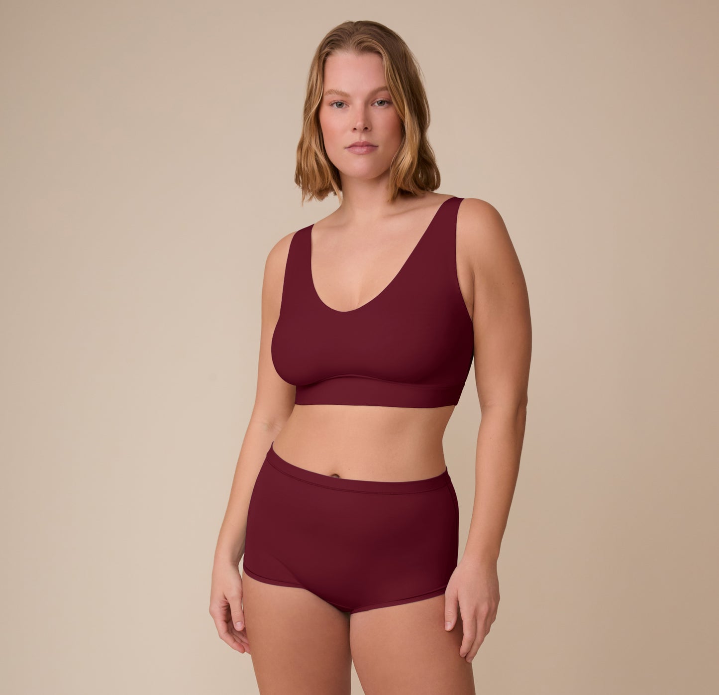 Sonnie wearing the Bliss Boyshort and matching Bliss Bralette in Bordeaux. She stands confidently, showing the full coordinated set.