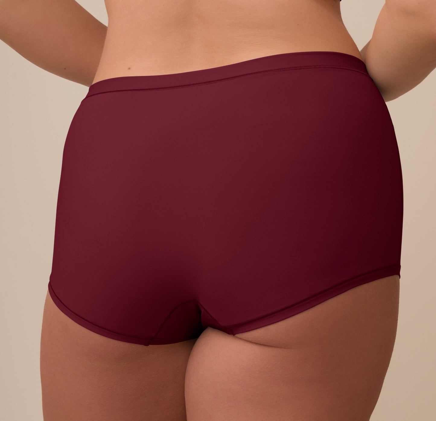 A detailed rear view of the Bliss Boyshort in Bordeaux on Sonnie, focusing on the smooth finish and soft fabric at the waistband and leg openings.