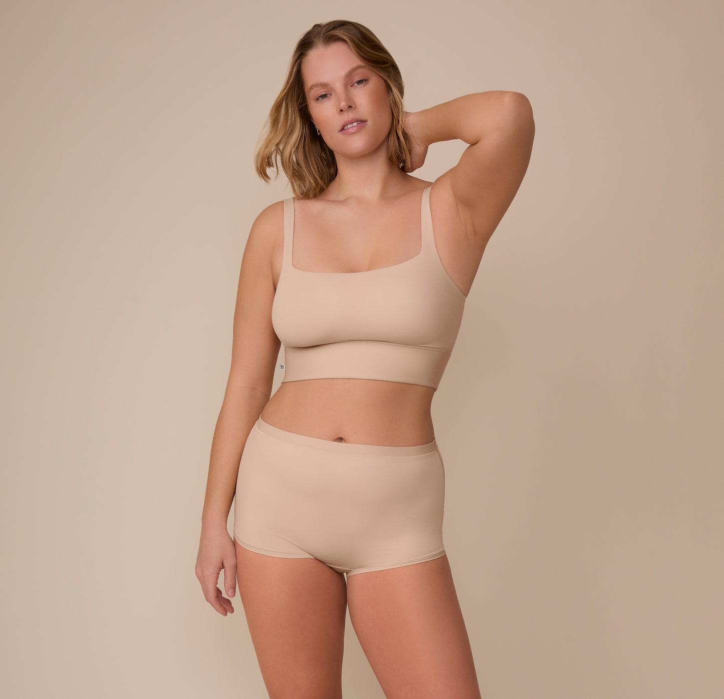 Sonnie wearing the Bliss Boyshort in Beige, paired with the matching Bliss Square Neck Bralette. She stands confidently, emphasizing the modern design of the boyshort.