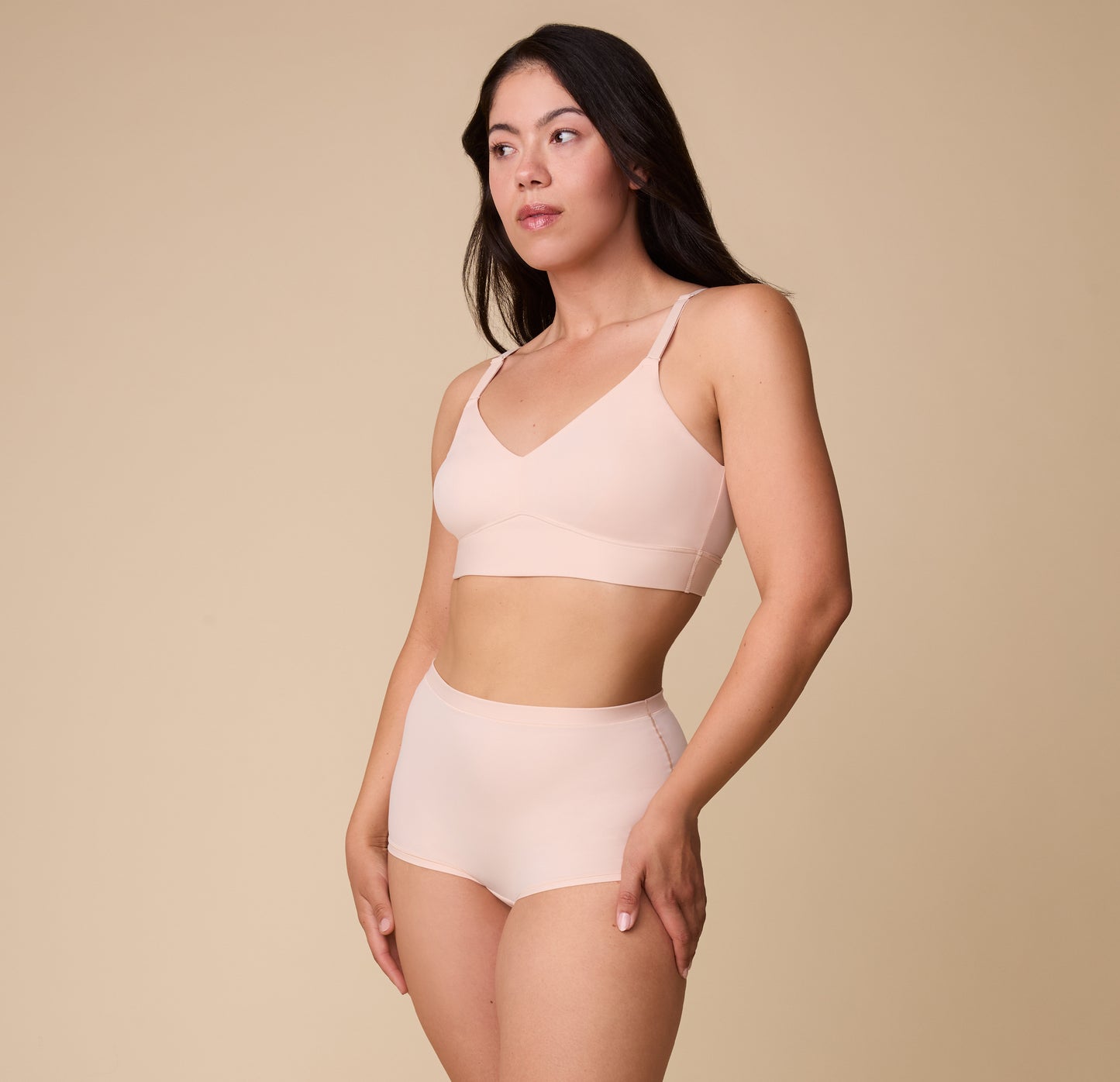 Emersyn wears the Bliss Boyshort in Rose paired with the matching Bliss Triangle Bralette, posing confidently against a neutral backdrop.