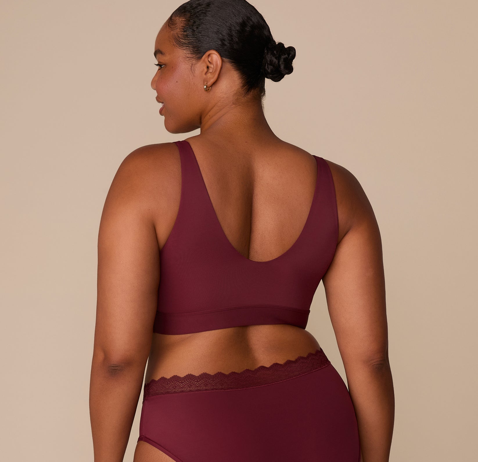 Back view of Zarria showing the seamless band and low scoop back of the Bliss Bralette in Bordeaux.