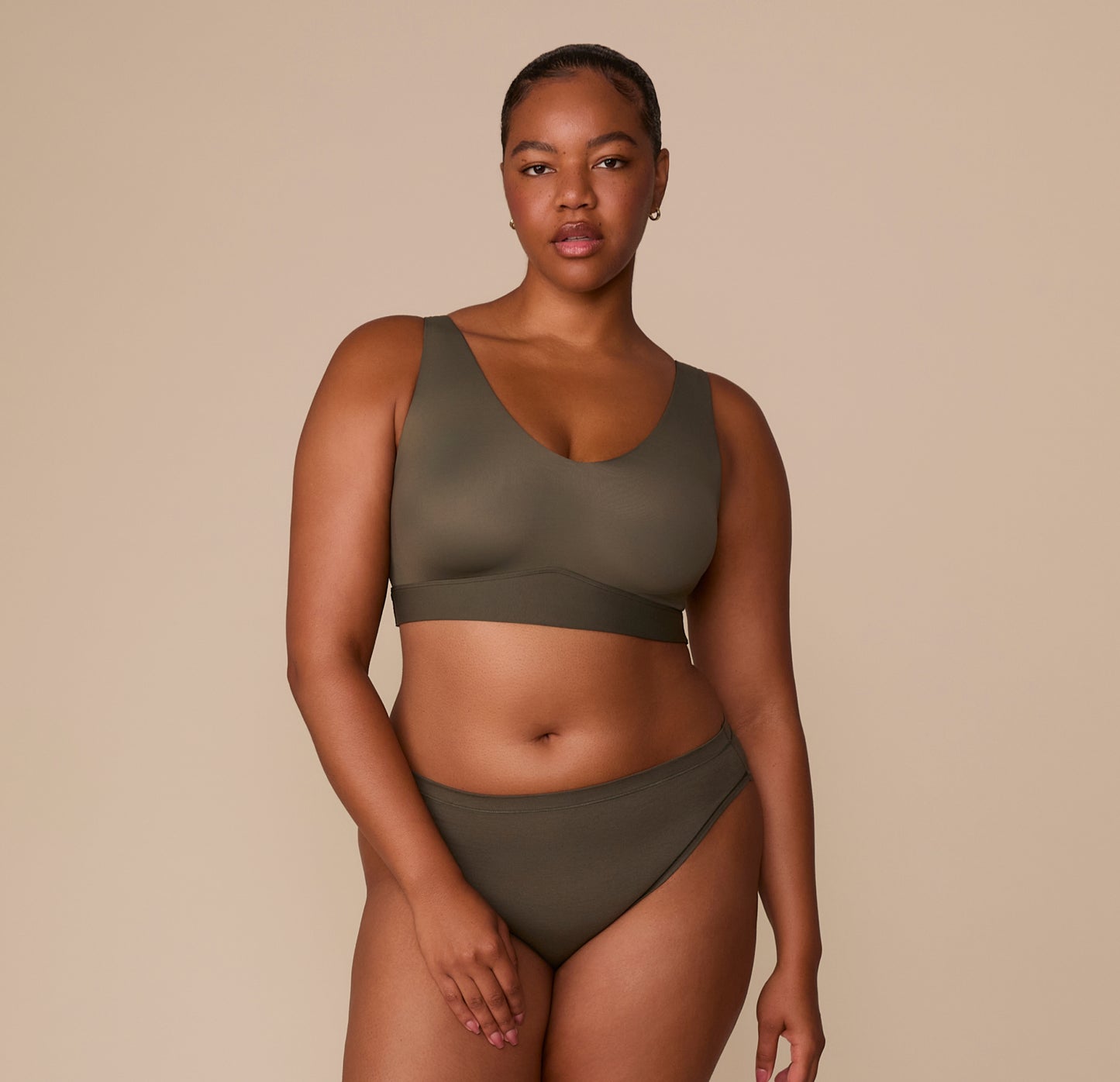 Full body view of Zarria in the Bliss Bralette and Bliss Bikini in Olive, styled as a coordinating set to highlight the rich neutral tone.