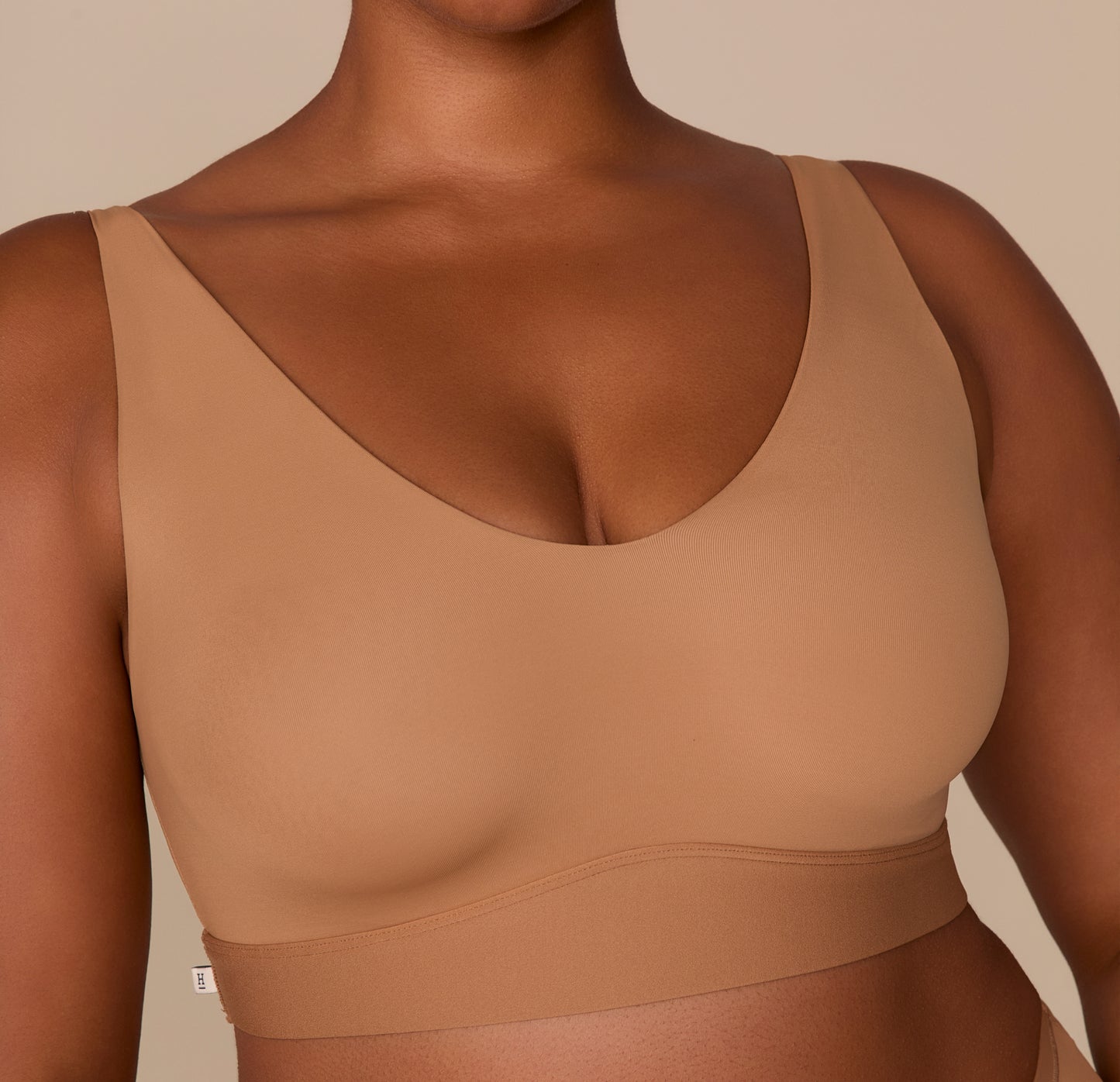 A close-up view of the front of the Bliss Bralette in Tan, showing the clean neckline, buttery-soft fabric, and molded support.