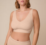 Front view of Victoria wearing the Bliss Bralette in Beige. The wide straps and deep V neckline showcase the ultra-soft fabric and smooth fit with minimal seams. sizing: Sonnie wears size XL