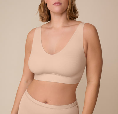 Front view of Victoria wearing the Bliss Bralette in Beige. The wide straps and deep V neckline showcase the ultra-soft fabric and smooth fit with minimal seams. sizing: Sonnie wears size XL