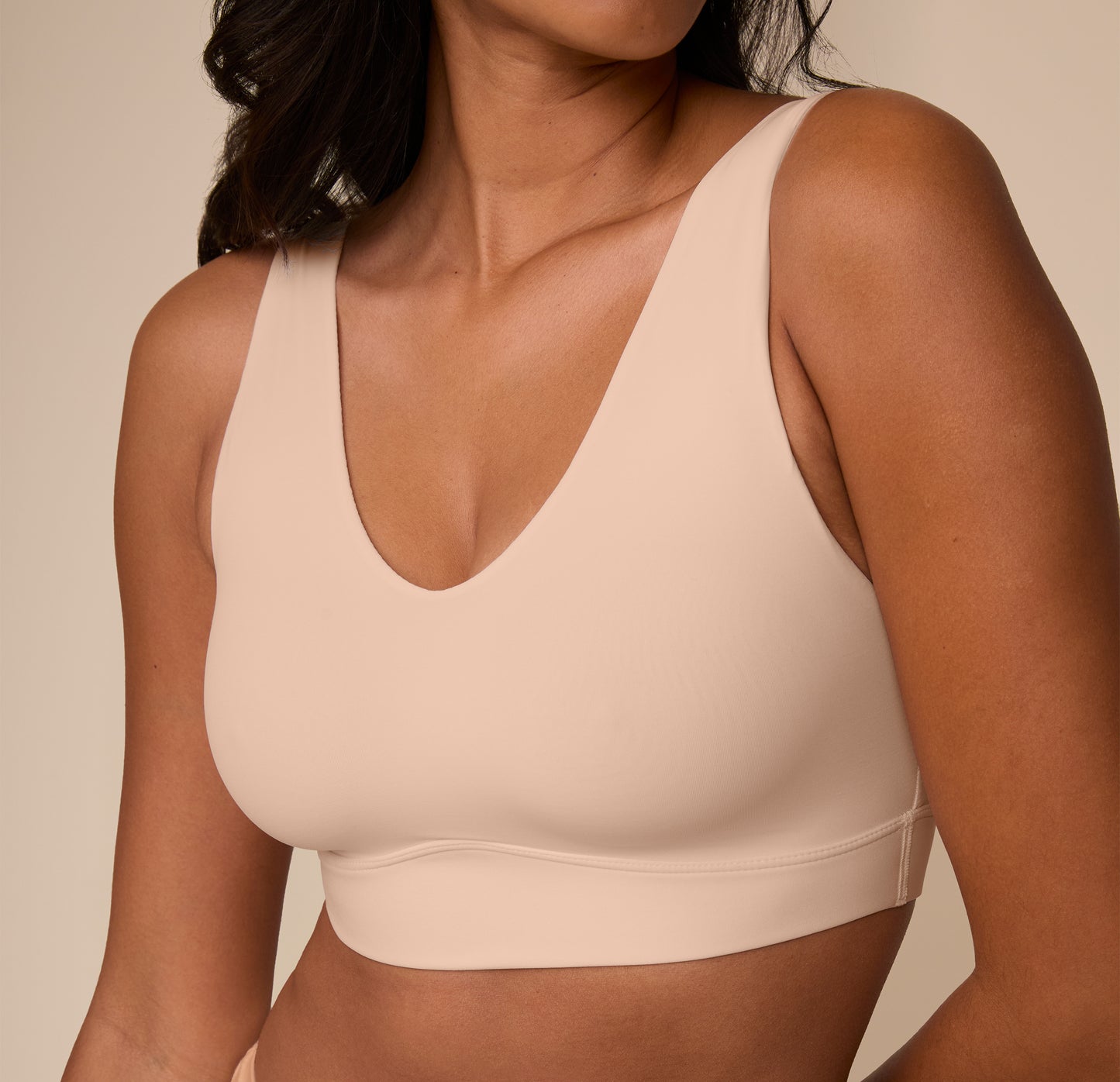 Close-up of Victoria wearing the Bliss Bralette in Beige. The image highlights the smooth fabric and barely-there seams built for all-day ease.