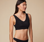 Three-quarter angle of Anna in the Bliss Bralette in Black. Her relaxed pose shows the bralette’s clean lines and flexible fit.