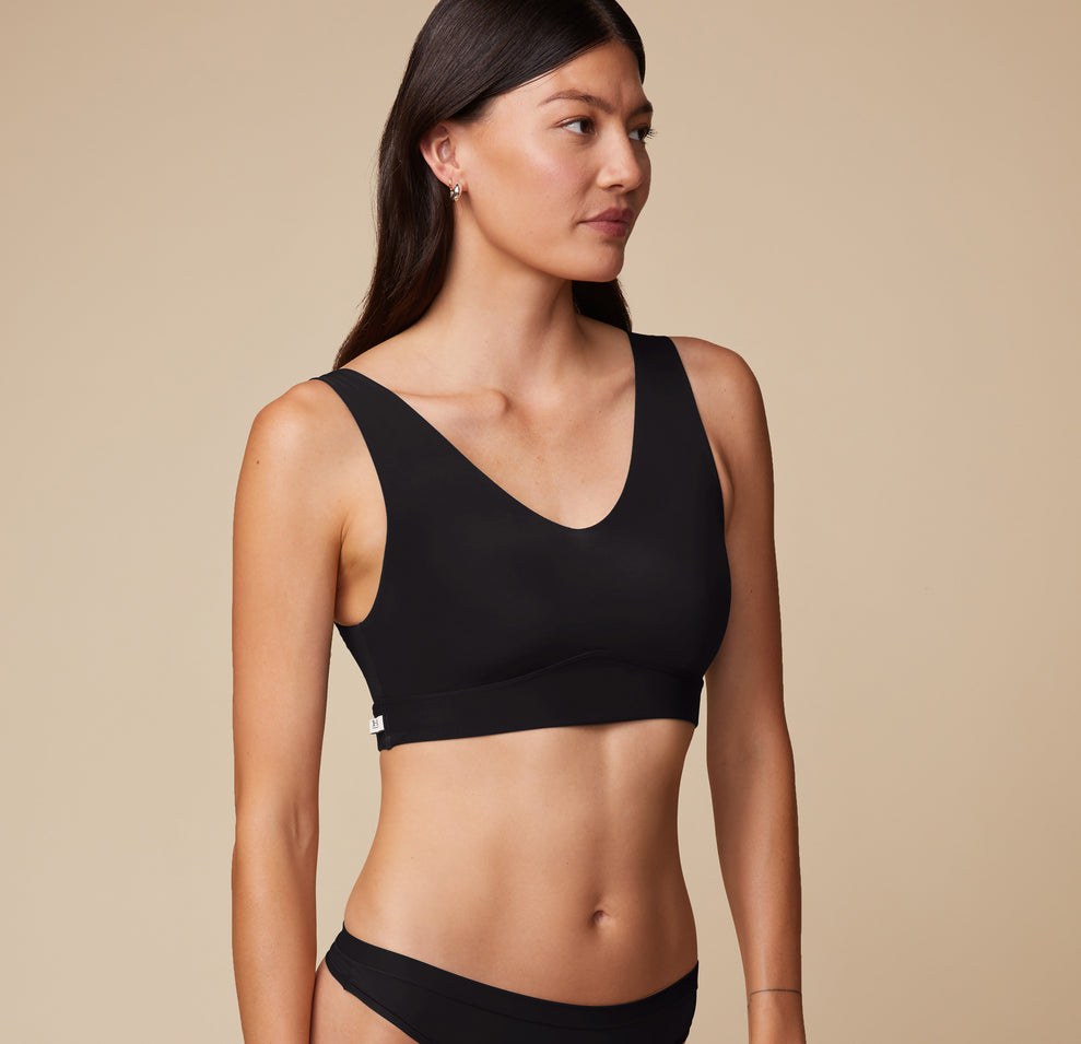 Three-quarter angle of Anna in the Bliss Bralette in Black. Her relaxed pose shows the bralette’s clean lines and flexible fit.