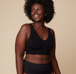 Front view of Akesha wearing the Bliss Bralette in Black. The supportive fit and clean neckline offer comfort and confidence in a timeless shade. sizing: Akesha wears size Large