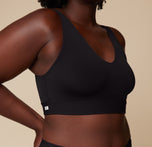 Close-up side view of Akesha wearing the Bliss Bralette in Black. The smooth stretch fabric and minimal seams contour to the body without squeezing.