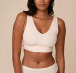 Front view of Victoria wearing the Bliss Bralette in Quartz. Victoria models the Bliss Bralette in Quartz, featuring a moderately low V-neckline and wide shoulder straps. The minimal seam cups offer gentle lift and all-day comfort. sizing: Victoria wears size Medium